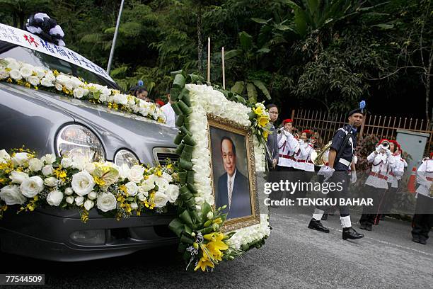 Portrait of late gaming tycoon Lim Goh Tong is displayed on the hood of a hearse bearing his coffin during a funeral procession in Genting Highlands,...