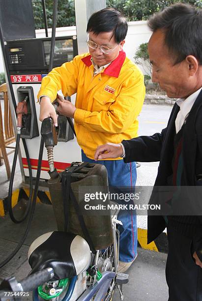 Petrol station attendant at work pumps gasoline at a PetroChina outlet in Shanghai, 29 October 2007. PetroChina, the country's largest oil and gas...