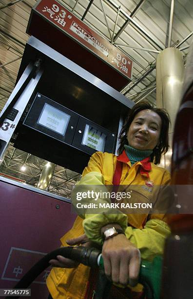 Petrol station attendant at work pumping gasoline at a PetroChina outlet in Shanghai, 29 October 2007. Fuel shortages were reported at petrol...