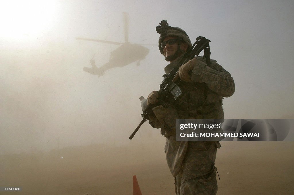 A US soldier stands guard as Blackhawk h