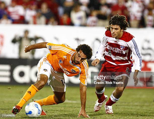Houston Dynamo midfielder Dwayne De Rosario moves the ball away from FC Dallas midfielder Juan Toja during the first game of the Western Conference...