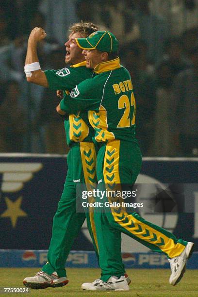 Johan Botha celebrates a catch by AB de Villiers during the Fifth One Day International match between Pakistan and South Africa at Gaddafi Stadium on...