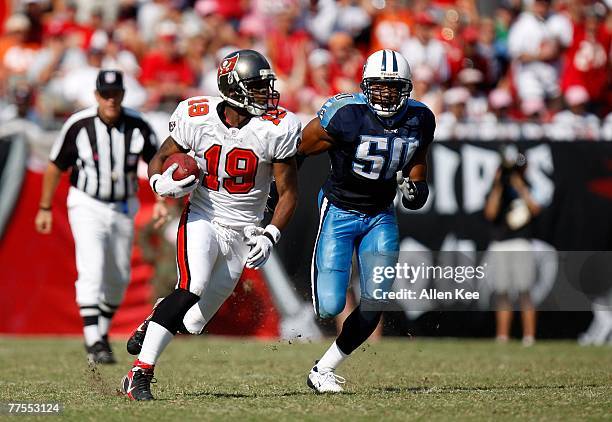 Ike Hilliard of the Tampa Bay Buccaneers gains yards as David Thornton of the Tennessee Titans closes in at Raymond James Stadium on October 14, 2007...