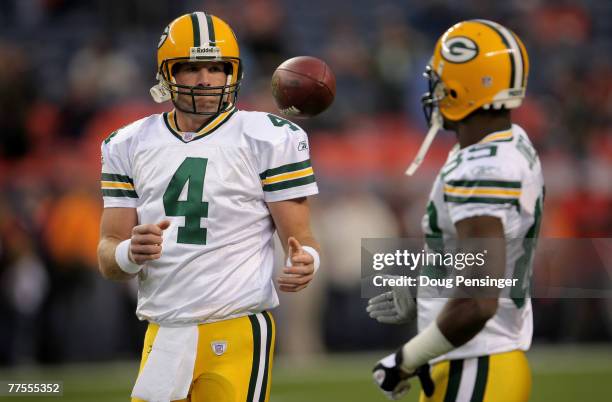 Brett Favre of the Green Bay Packers takes the ball from Greg Jennings before a Monday Night Football game against the Denver Broncos at Invesco...