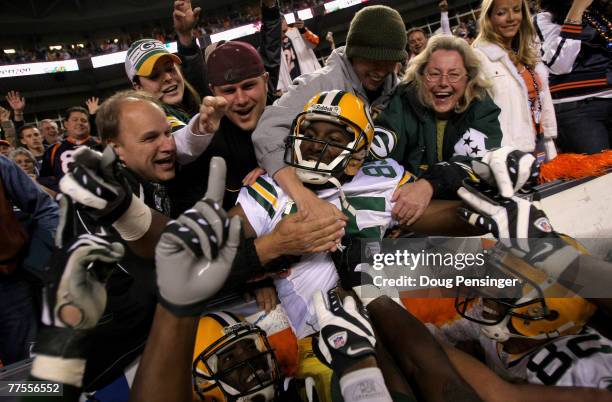 Greg Jennings of the Green Bay Packers is hoisted into the stands by his teammates after catching an 82-yard game-winning touchdown pass from Brett...