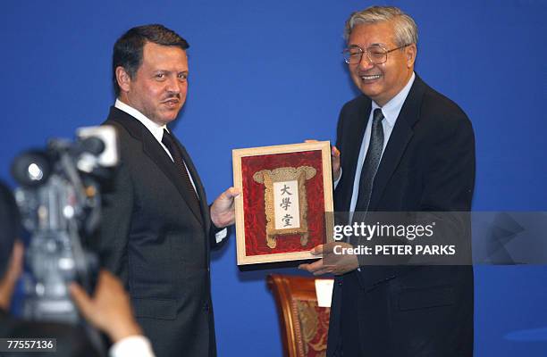 Jordan's King Abdullah II receives a souvenir from the president of Peking University Xu Zhihong after Abdullah spoke to an audience of students at...