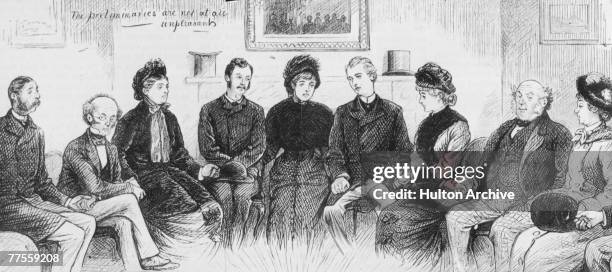 Group of people prepare to hold a seance in an attempt to make contact with the dead, circa 1880. Original Publication : Graphic Magazine.