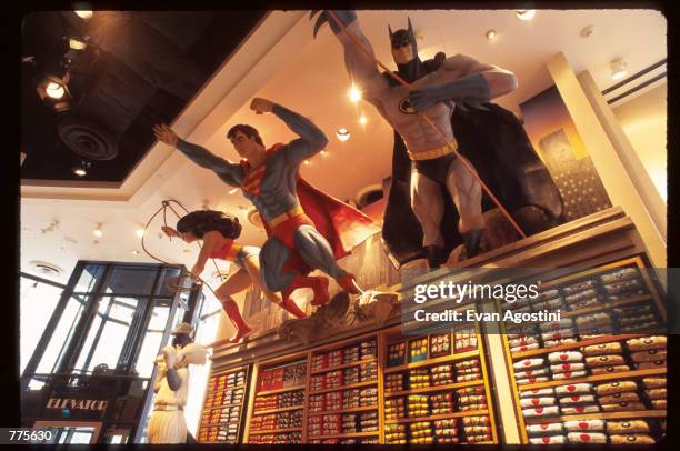 Figures of Wonder Woman, Superman, and Batman hang from a shelf at the Warner Bros. Studio store October 23, 1996 in New York City. The store,...