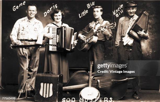 Portrait of musical group, the Sod Busters as they pose with their instruments, early twentieth century. They are, from left, Gene, Doris, Little...