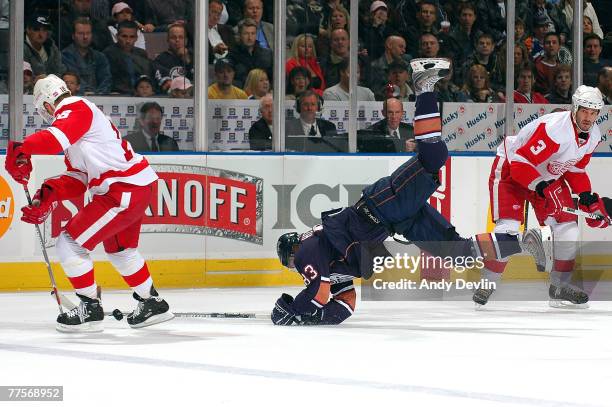 Ales Hemsky of the Edmonton Oilers falls while Andreas Lilja and Kirk Maltby of the Detroit Red Wings defend at Rexall Place October 30, 200 in...