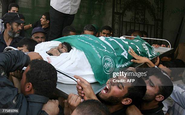 Palestinian mourn carry the body of Maher Abu Taer one of four fighters killed from Hamas' armed wing, the Ezzedine al-Qassam Brigades, during their...