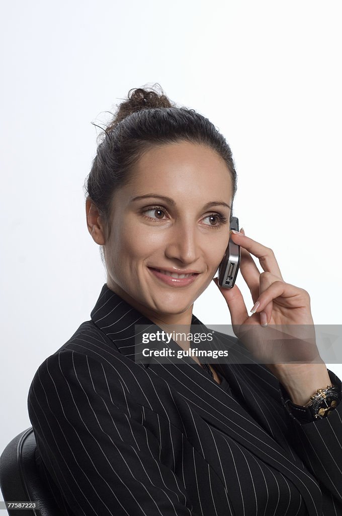 Young woman holding mobile phone, smiling