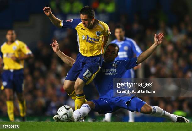 Alex of Chelsea tackles Matty Fryatt of Leicester City during the Carling Cup Fourth Round match between Chelsea and Leicester City at Stamford...