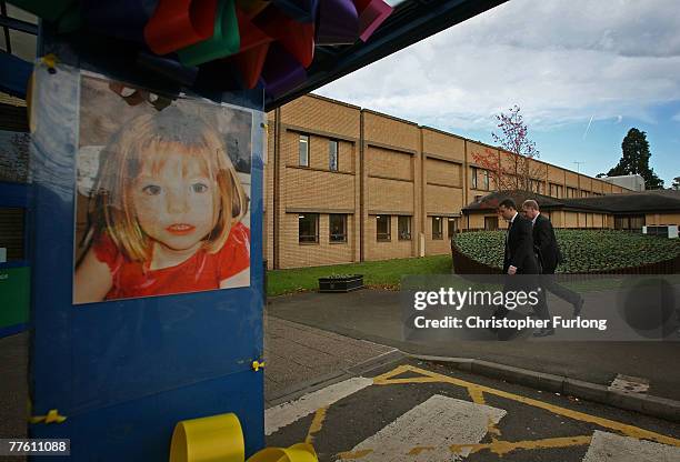 Gerry McCann , escorted by his advisor Clarence Mitchell, walks past a poster of his missing daughter as he returns to work at Glenfield Hospital,...