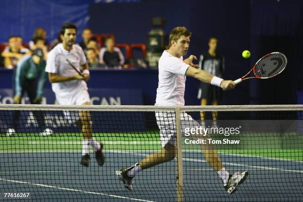 Simon Aspelin of Sweden hits the ball as his partner Julian Knowle of Austria looks on in their match against Paul-Henri Mathieu of France and Jarkko...