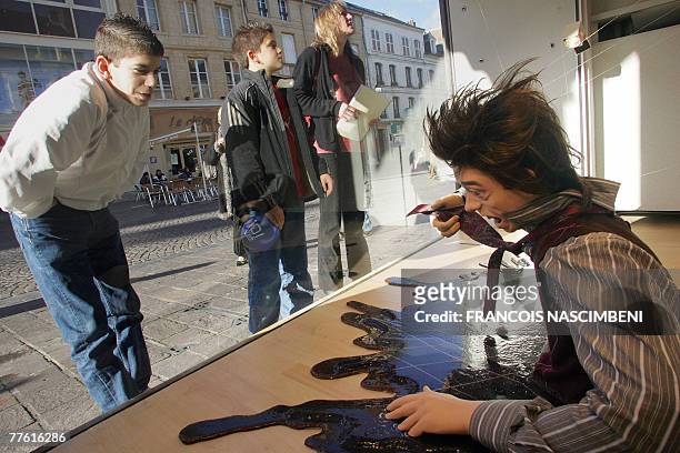 People look at "Le Cauchemar de la Flaque" , a marionette created by French street theatre company, Royal de Luxe, exposed in a window shop as part...