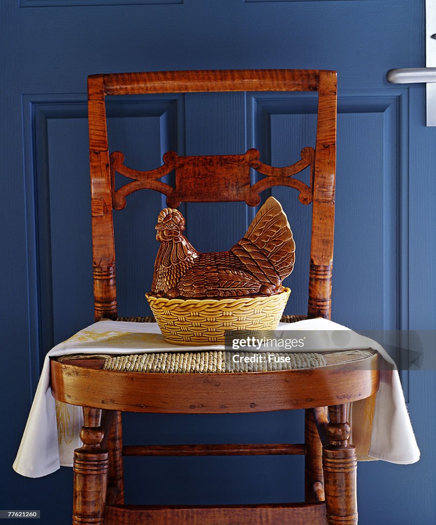 Statuette of a rooster kept on the chair near the door