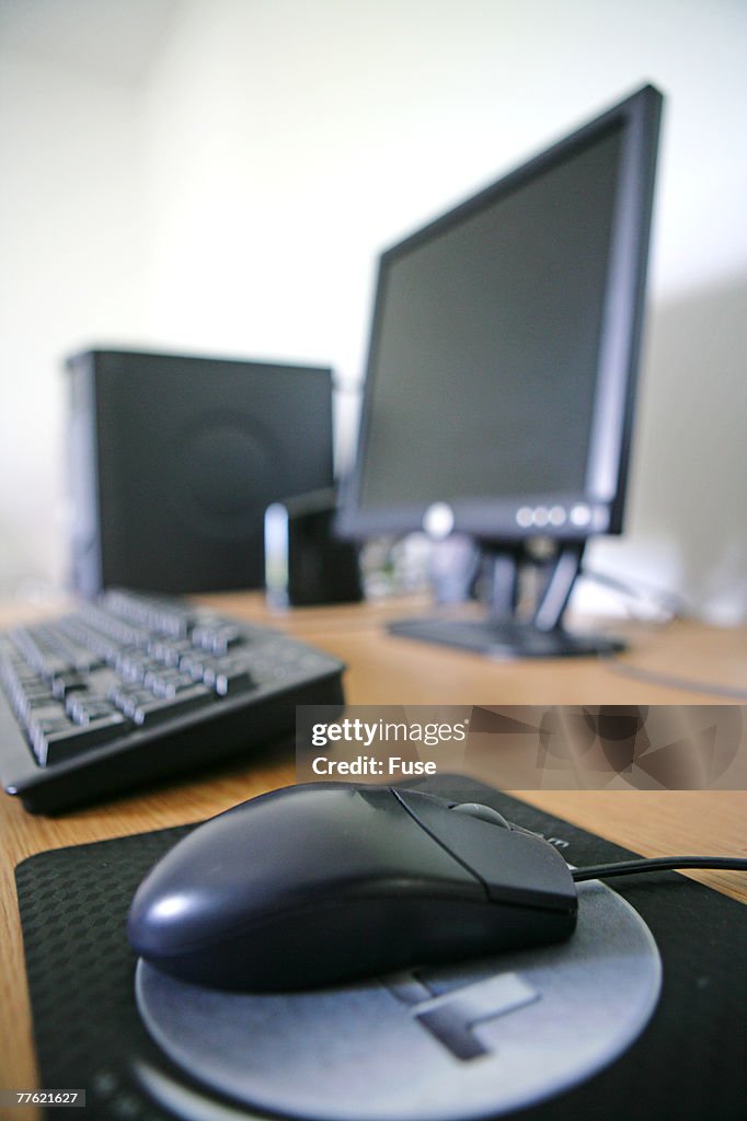 Black mouse with blurred computer in background