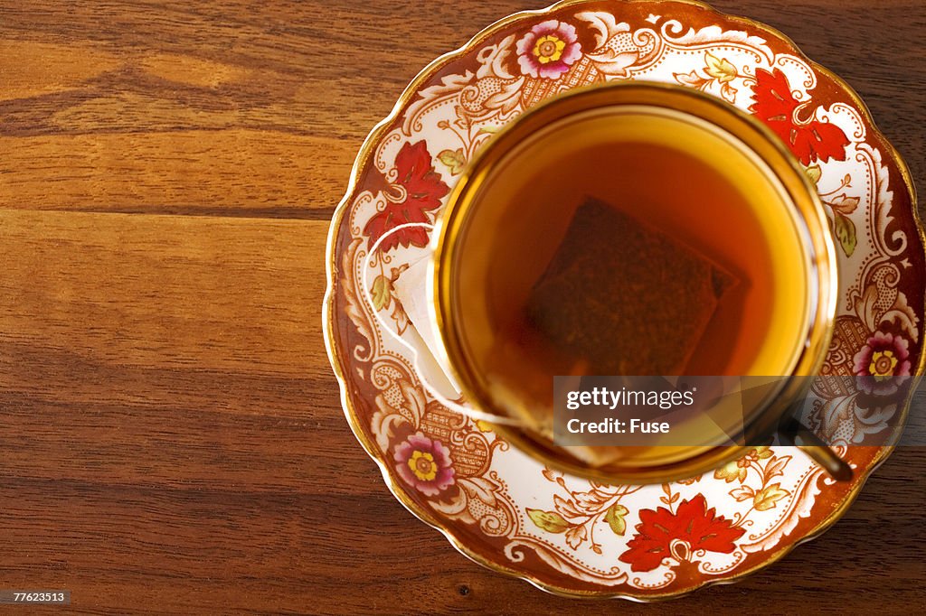 Above view of floral pattern teacup and saucer on hardwood table