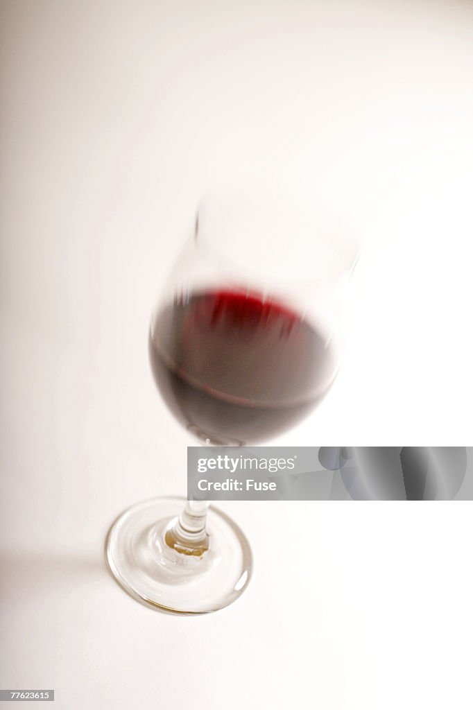 Single blurred glass of red wine