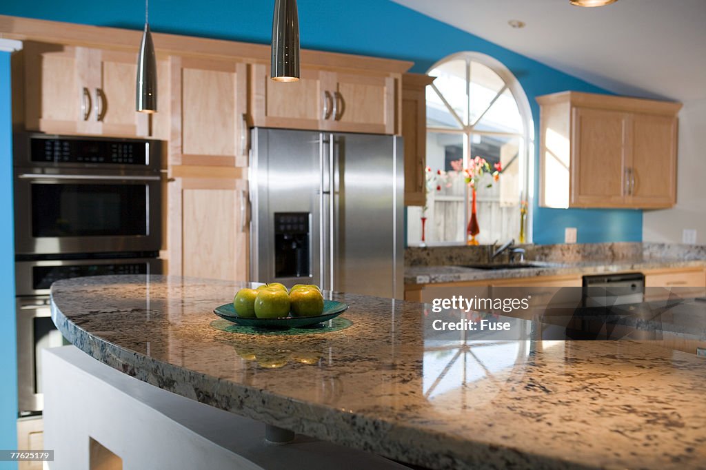 Apples are kept on the counter in a neat and clean kitchen