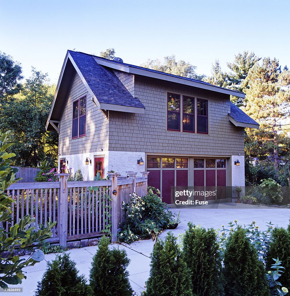 An elegant house is seen surrounded with plants and trees