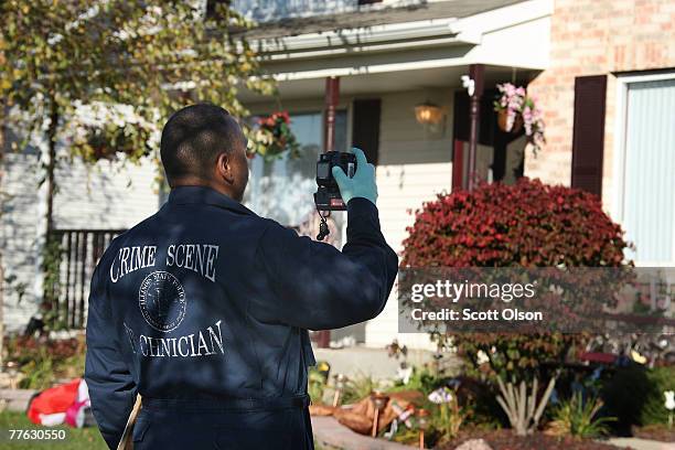 An Illinois State Police crime scene technician photographs the home of Bolingbrook police Sgt. Drew Peterson whose fourth wife was recently reported...