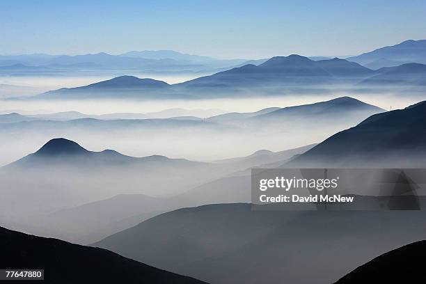 Fire-repressing fog from the ocean marine layer fills valleys on the Mexico side of the border south of the recent 80,000-acre Harris Fire below an...