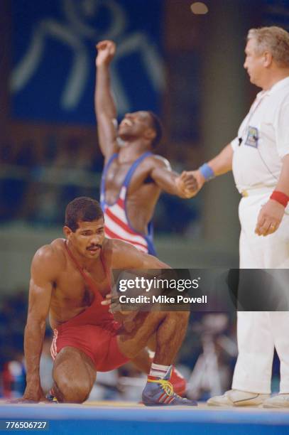 Cecilio Rodríguez of Cuba kneels on the floor as Rodney Smith of the United States celebrates behind him after Smith beat Rodriguez to win the bronze...