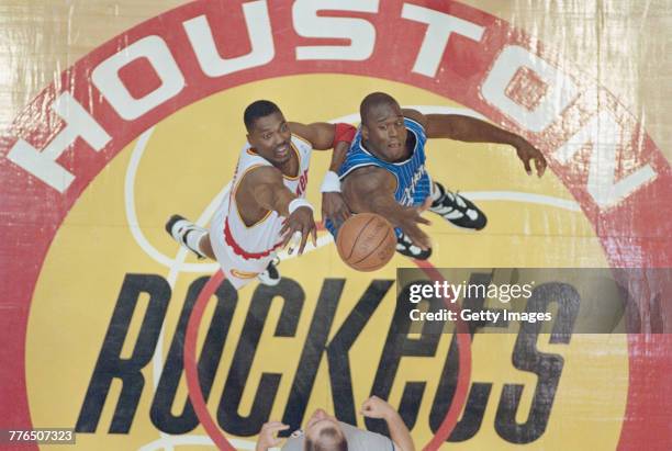 Hakeem Olajuwon of the Houston Rockets of the Western Conference contests the ball at the tip off against Shaquille O'Neal of the Orlando Magic of...