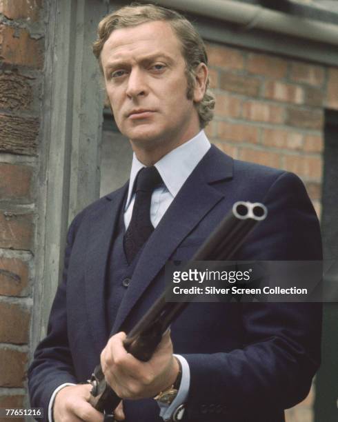 British actor Michael Caine toting a shotgun on the set of 'Get Carter', circa 1971.