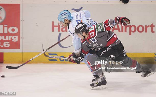 Sebastian Furchner of Cologne and Peter Sarno of Hamburg fight for the puck during the DEL match between Hamburg Freezers and Koelner Haie at the...