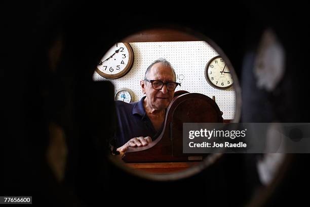 Howie Brown is seen through a clock being repaired as he adjusts the time on a clock back one hour for the end of day light savings time at Brown's...