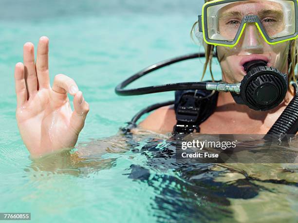 scuba diver in tropical water giving ok sign - scuba regulator stock pictures, royalty-free photos & images