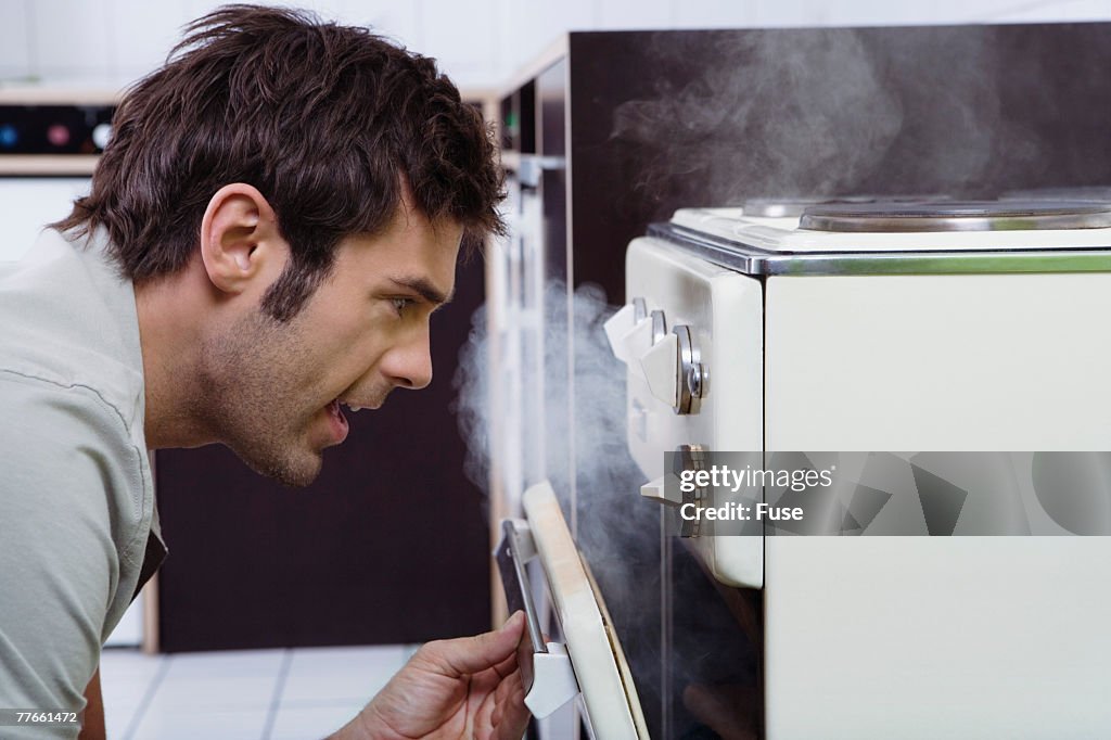 Man Looking in Smoking Oven