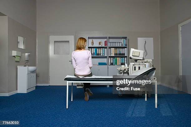 woman waiting in examination room - frau mittleren alters stock-fotos und bilder