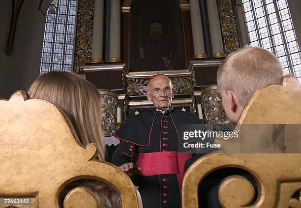 couple and priest during marriage ceremony - habit clothing stock-fotos und bilder