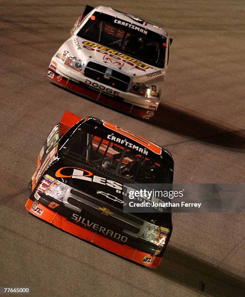 Tim Sauter, driver of the Lester Buildings/ASI Limited Chevrolet, races against Mike Bliss, driver of the Open Joist/Dodge, during the NASCAR...