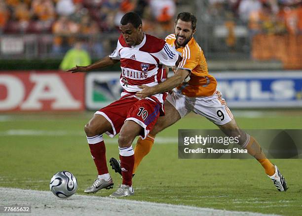 Brian Mullan of the Houston Dynamo fights for possession against Denilson of FC Dallas in the Western Conference Semifinals second leg at Robertson...