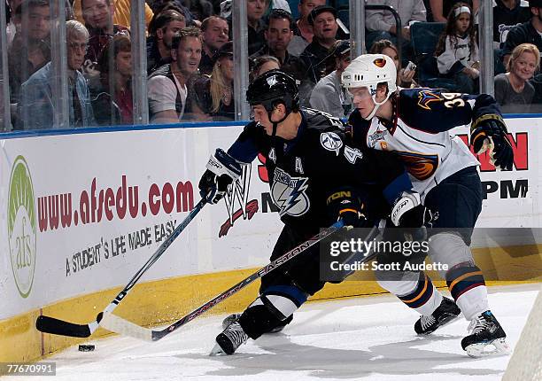 Vincent Lecavalier of the Tampa Bay Lightning goes into the corner against Mike Lundin of the Atlanta Thrashers at St. Pete Times Forum on November...