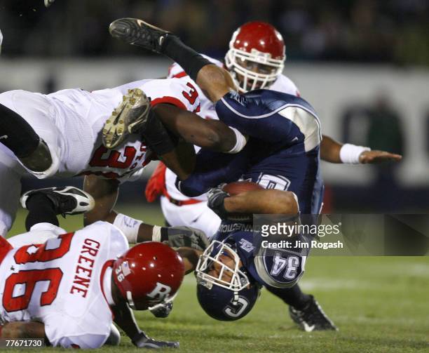 Donald Brown of the Connecticut Huskies gains yardage against Courtney Greene and George Johnson of the Rutgers Scarlet Knights at Rentschler Field...