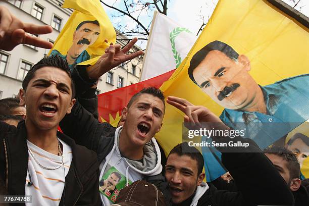 Young men shout and gesture under a portrait of imprisoned Kurdish leader Abdullah Ocalan at a protest of several thousand mostly Kurdish...