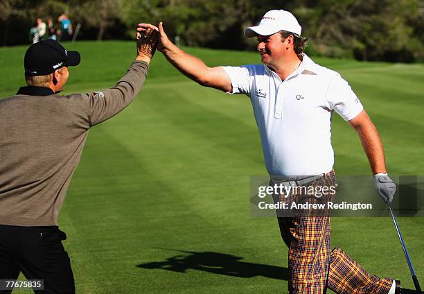 Graeme McDowell of Northern Ireland celebrates with playing partner Soren Kjeldsen of Denmark after holing his second shot for an albatross on the...