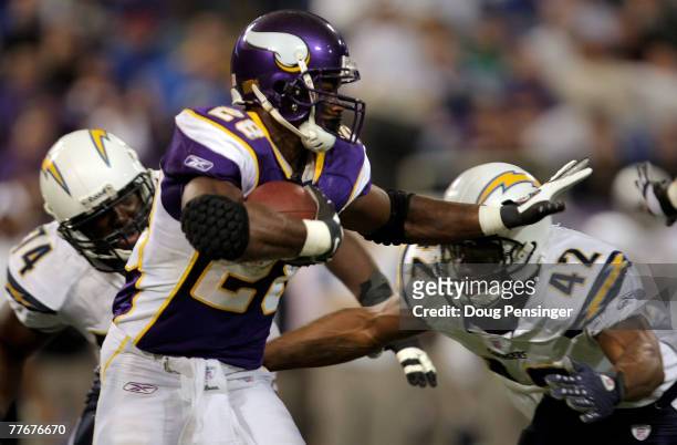 Adrian Peterson of the Minnesota Vikings rushes as Clinton Hart of the San Diego Chargers defends at the Hubert H. Humphrey Metrodome on November 4,...