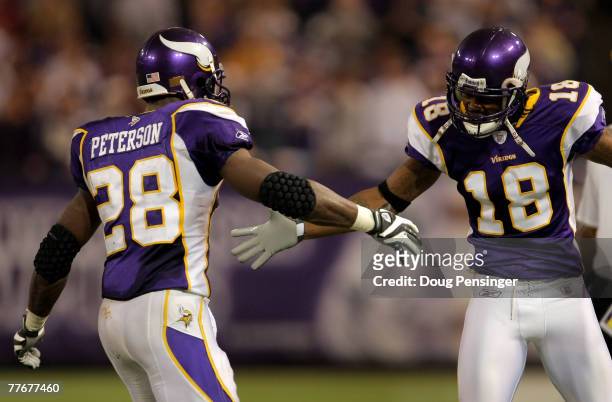 Adrian Peterson of the Minnesota Vikings is greeted at the sidelines by Sidney Rice after Peterson rushed 46 yards for a fourth quarter touchdown...