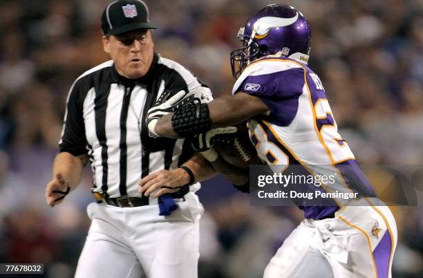 Adrian Peterson of the Minnesota Vikings collides with umpire Dan Ferrell as he rushes against the San Diego Chargers at the Hubert H. Humphrey...