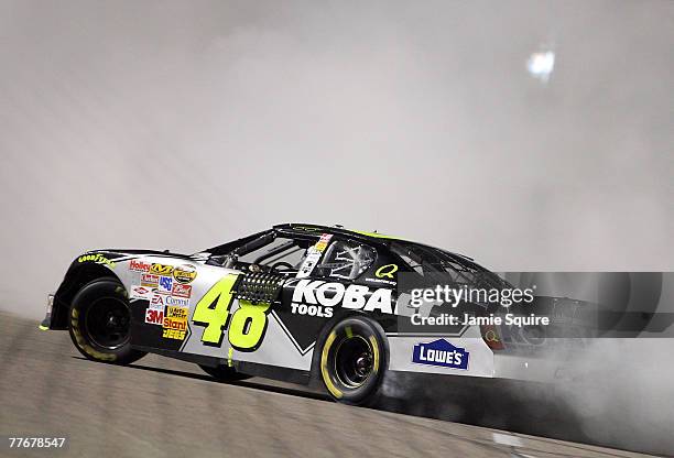 Jimmie Johnson, driver of the Lowe's/Kobalt Chevrolet, celebrates by burning out his tires after winning the NASCAR Nextel Cup Series Dickies 500 at...