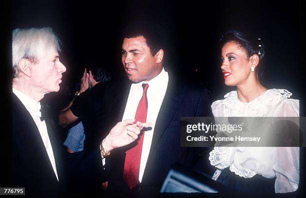 Pop artist Andy Warhol speaks with former Heavyweight Boxing champion Muhammad Ali and his wife Veronica during the Valentino Fashion Show held...