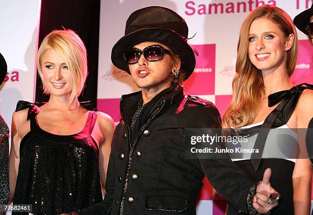 Paris Hilton and Nicky Hilton pose for photographs with a Japanese singer DJ Ozma at a press party announcing the launch of the new Christmas...