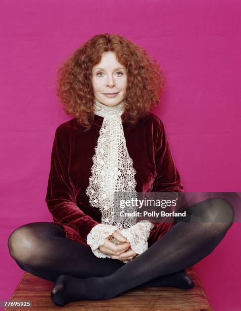 English actress Sarah Miles wearing a red velvet jacket and lace cravat, circa 1995.